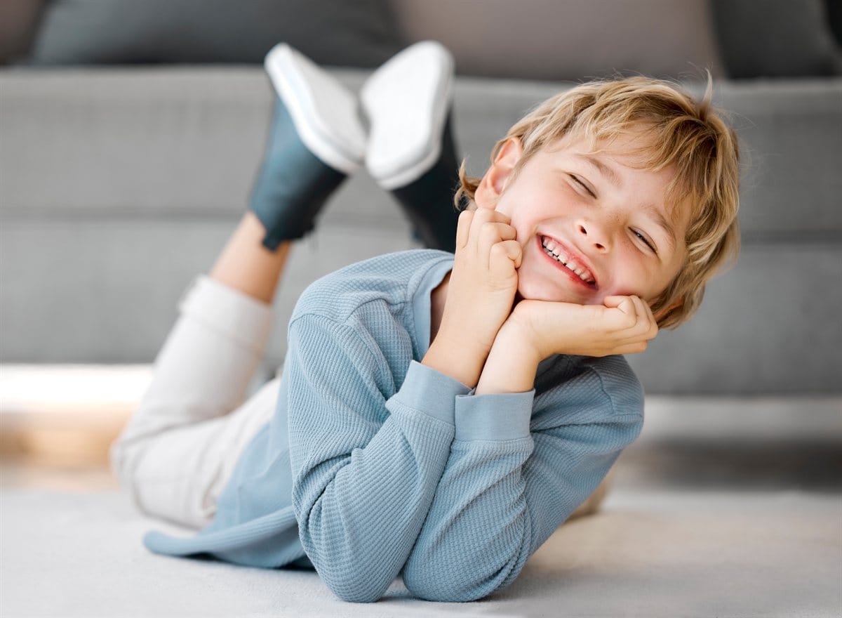 A happy boy relaxing on the floor at home